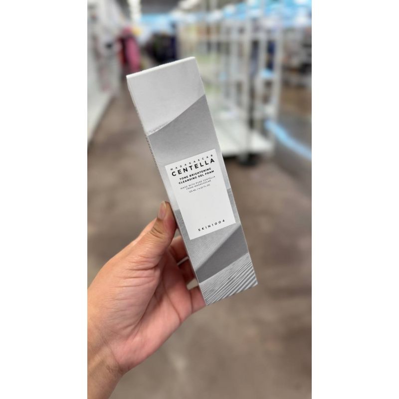 Skin1004 Madagascar Centella Tone Brightening Cleansing Gel Foam e um limpador em gel que remove impurezas enquanto ajuda a iluminar a pele. Contem Centella de Madagascar para acalmar e hidratar. Promove limpeza suave sem agredir a barreira cutanea.